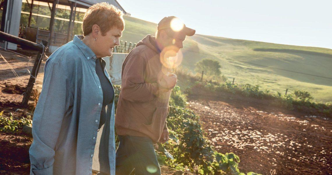 Two farmers walking outside at golden hour